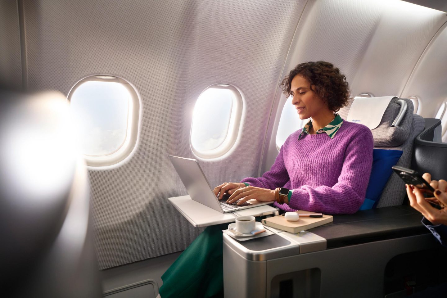 Discover FlyNet A woman in Business Class looks at her laptop