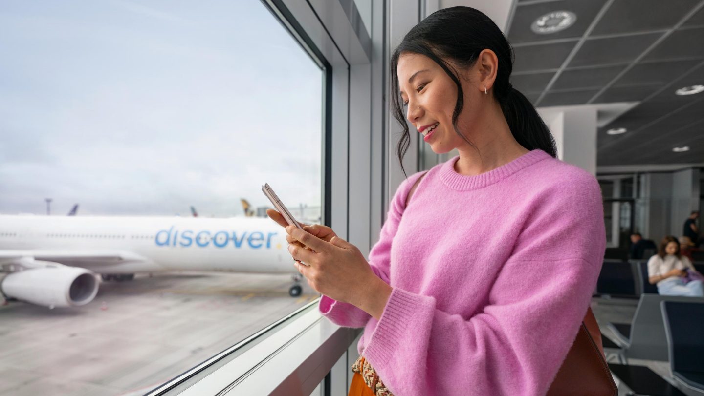 A woman uses her smartphone at the gate