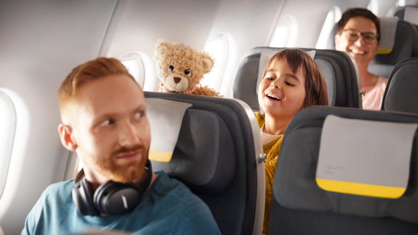A child playing with a teddy bear in Economy Class on an A330