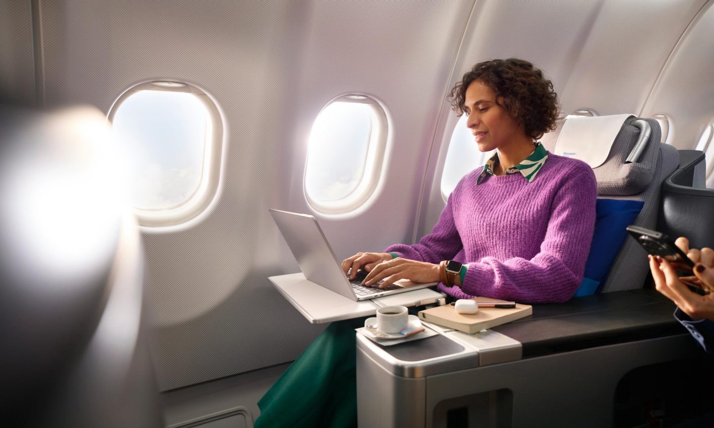 A woman in business class looking at her laptop