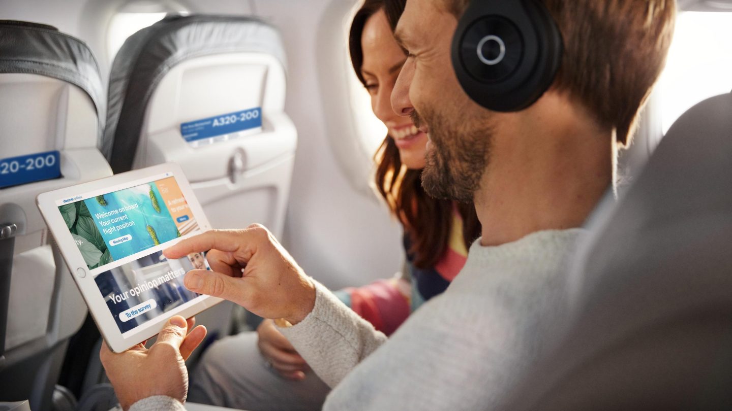 A man wearing headphones and looking at the Onboard Cloud on his tablet
