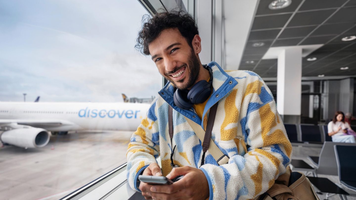 Reisender am Gate vor einem Discover Airlines Flugzeug