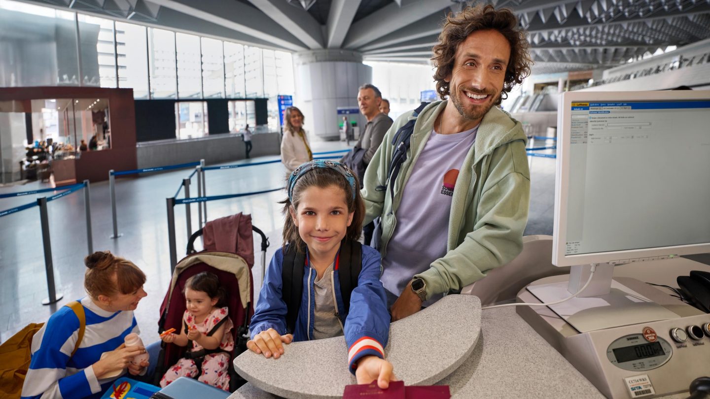 A family with young children checking in for their flight at the counter