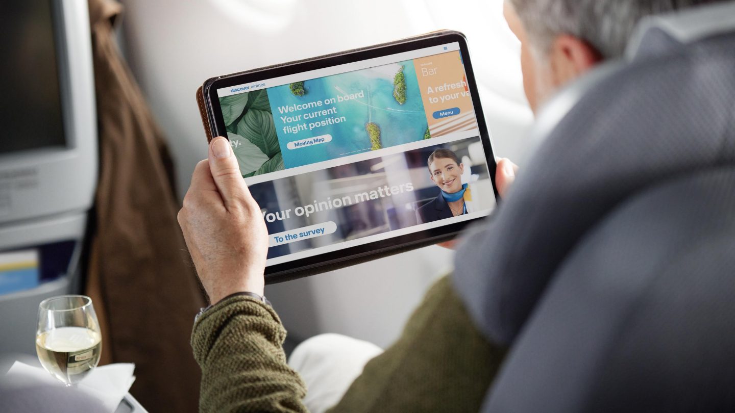 Ein Mann hält ein Tablet in der Hand und schaut sich die Onboard Cloud an
