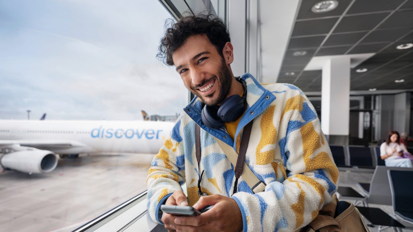 A man standing at the gate, holding a phone