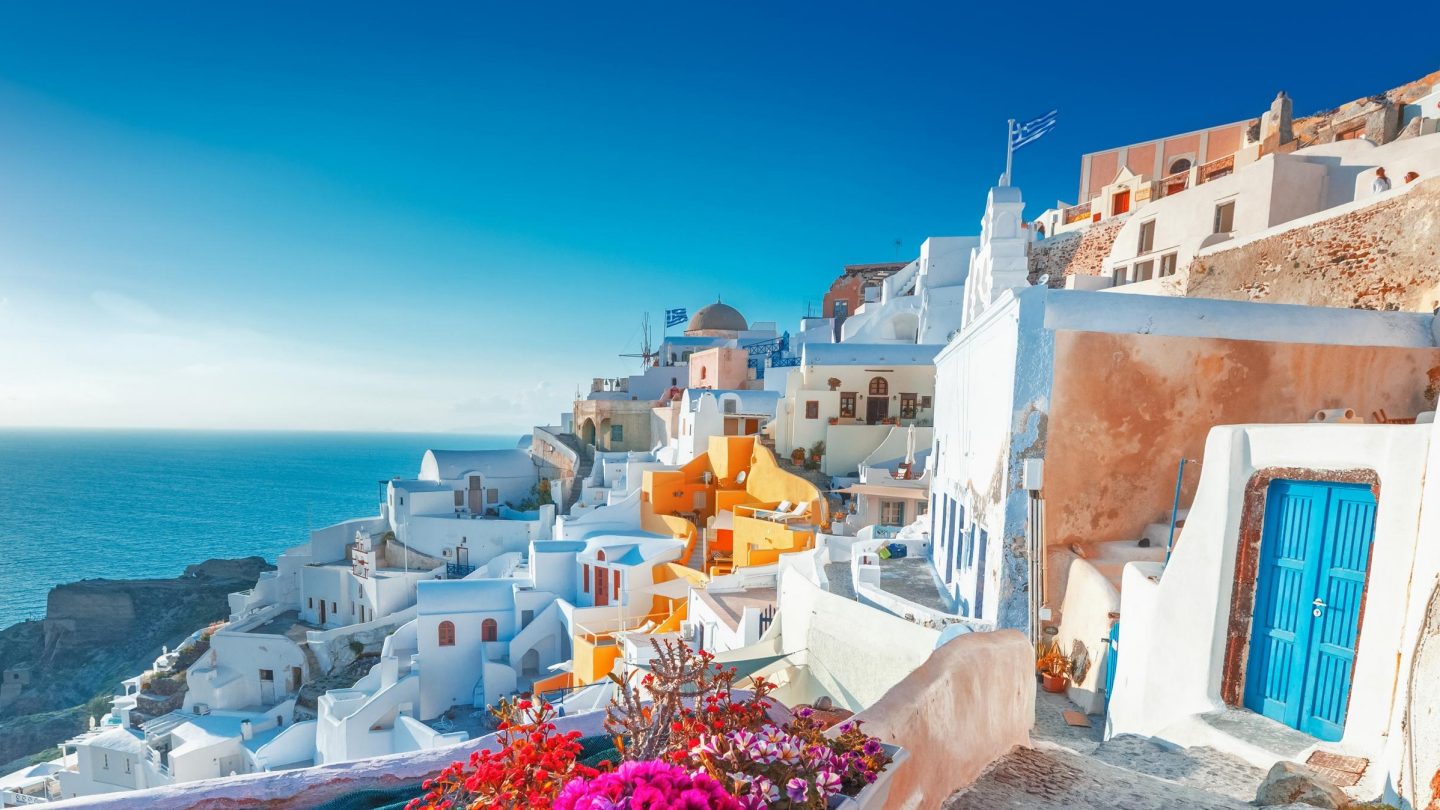 Blick auf die Steilküste von Santorin mit weißen Häusern und dem Meer im Hintergrund