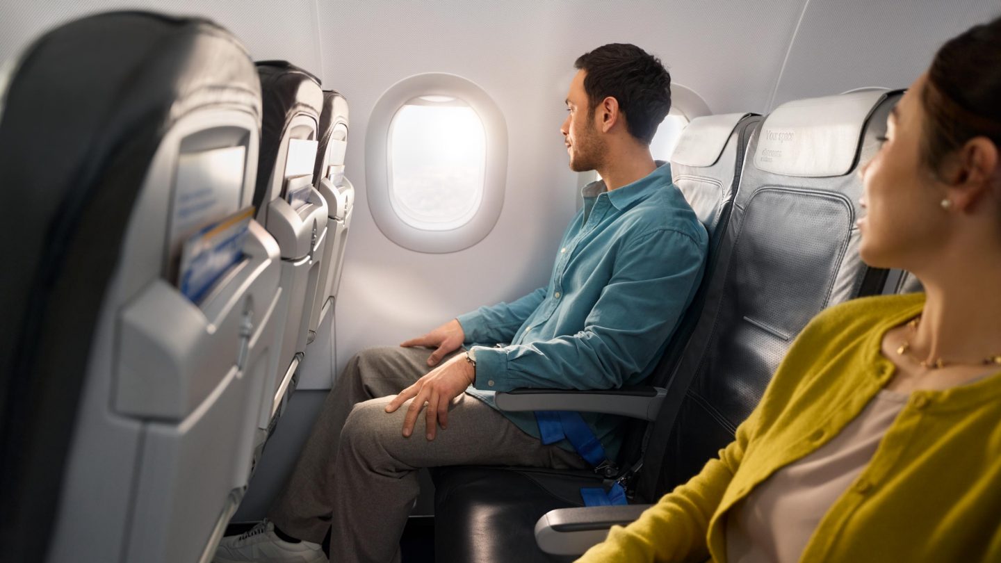 A man and woman sitting in Business Class in an A320 aircraft