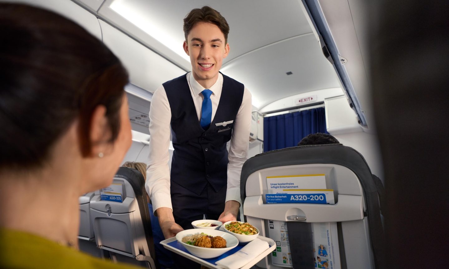 Passenger is given a special meal by the flight attendant