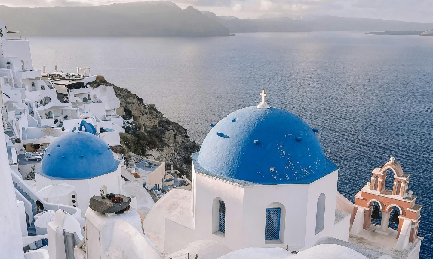 Blue roofs and white houses seen against the sea on Santorini Blue roofs and white houses seen against the sea on Santorini