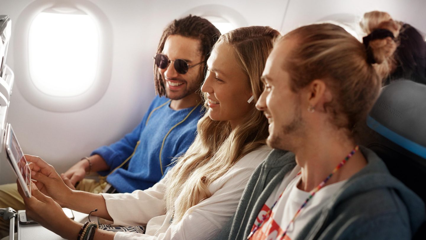 Drei Freunde sitzen in der Economy Class