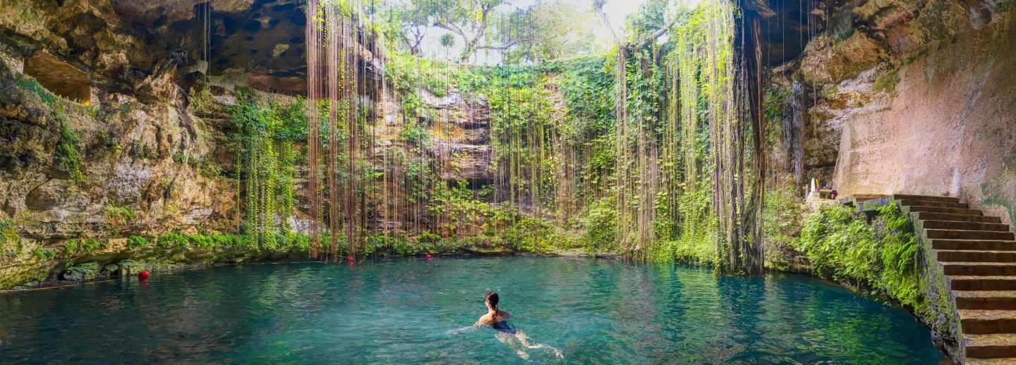 Eine Frau schwimmt in den Cenoten der Riviera Maya, Mexiko