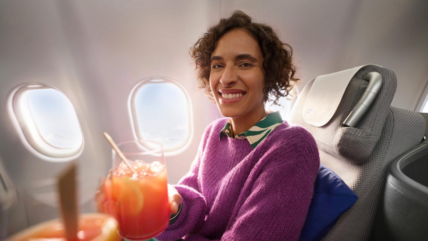 A woman with a cocktail in Business Class