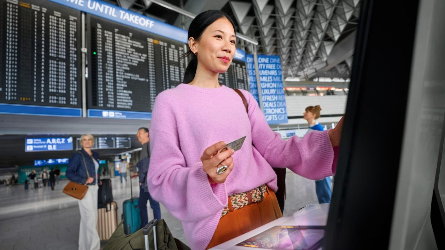 Eine Frau nutzt den Self Check-in Automaten