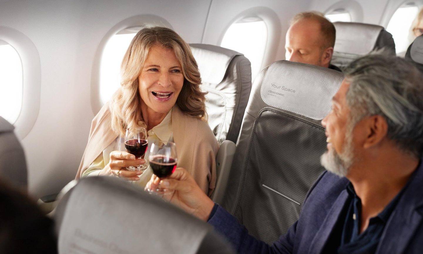 Business Class short-haul Couple toasting with glasses of red wine