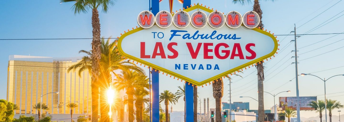 Das Bild zeigt einen Boulevard in Las Vegas mit einem Schild im Vordergrund, auf dem Fabulous Las Vegas steht