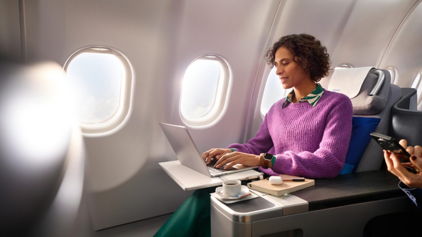 A woman in business class looking at her laptop