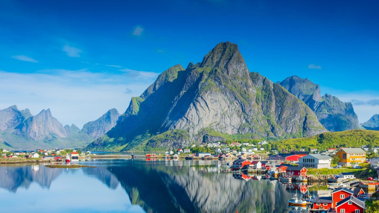 Fjord in Evenes, Norway with colourful small houses in the front and mountains in the back