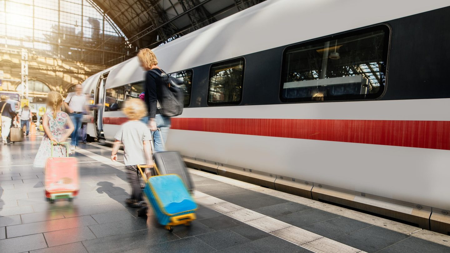 Eine Familie am Bahnhof vor einem ICE