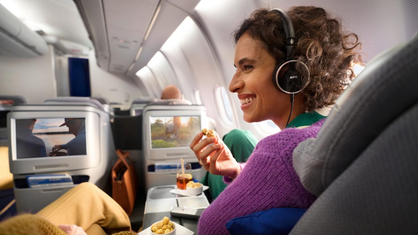 Frau in der Business Class isst Nüsse