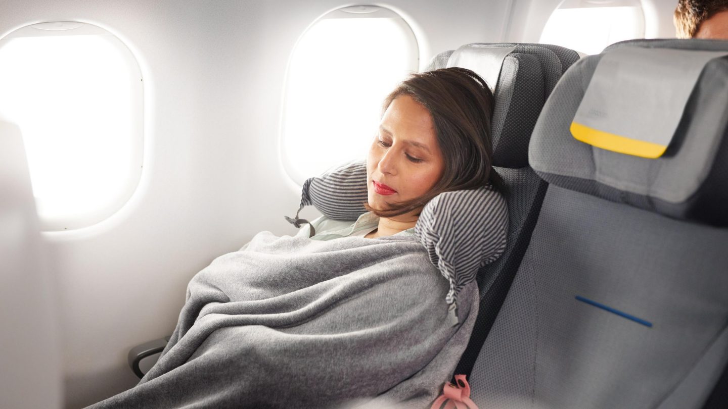 A woman with a blanket in Economy Class