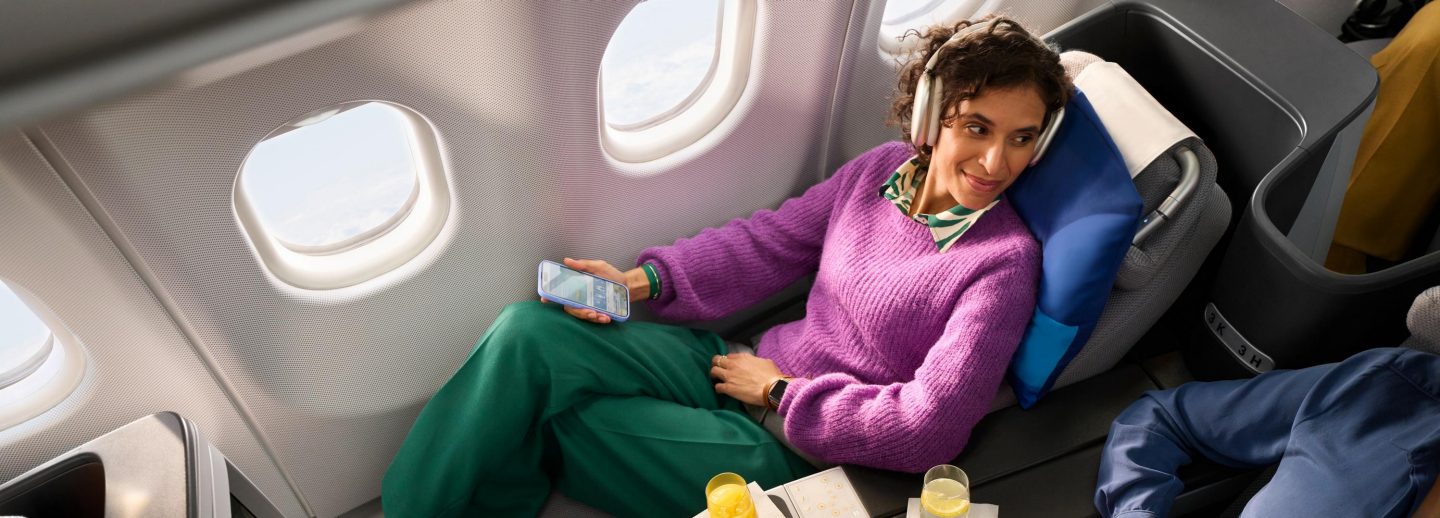 Eine Frau sitzt entspannt in der Business Class von Discover Airlines