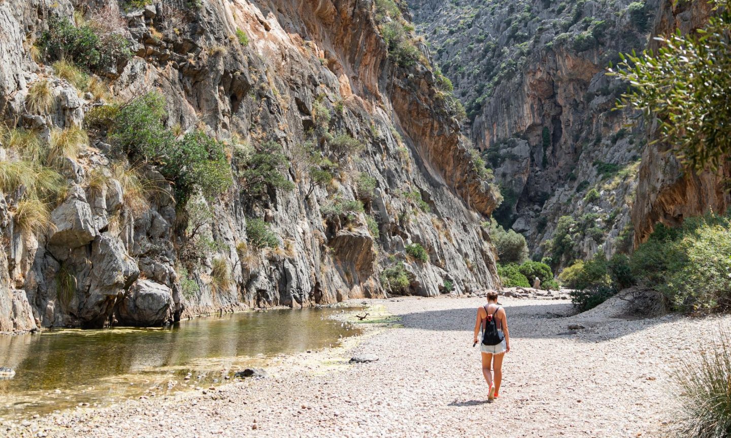 A woman running through the canyon of Torrent de Pareis