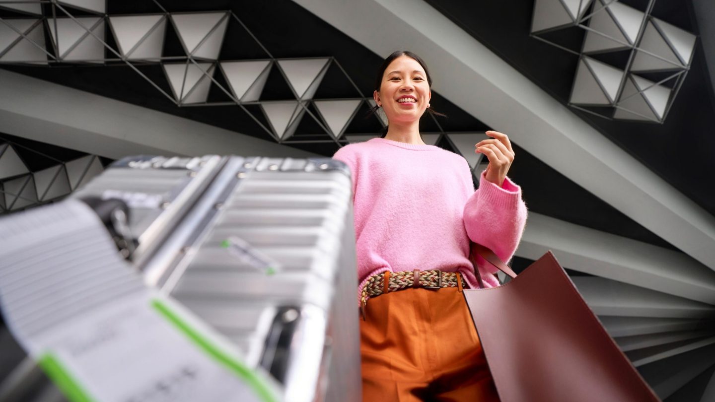 A woman depositing her suitcase at the check-in counter