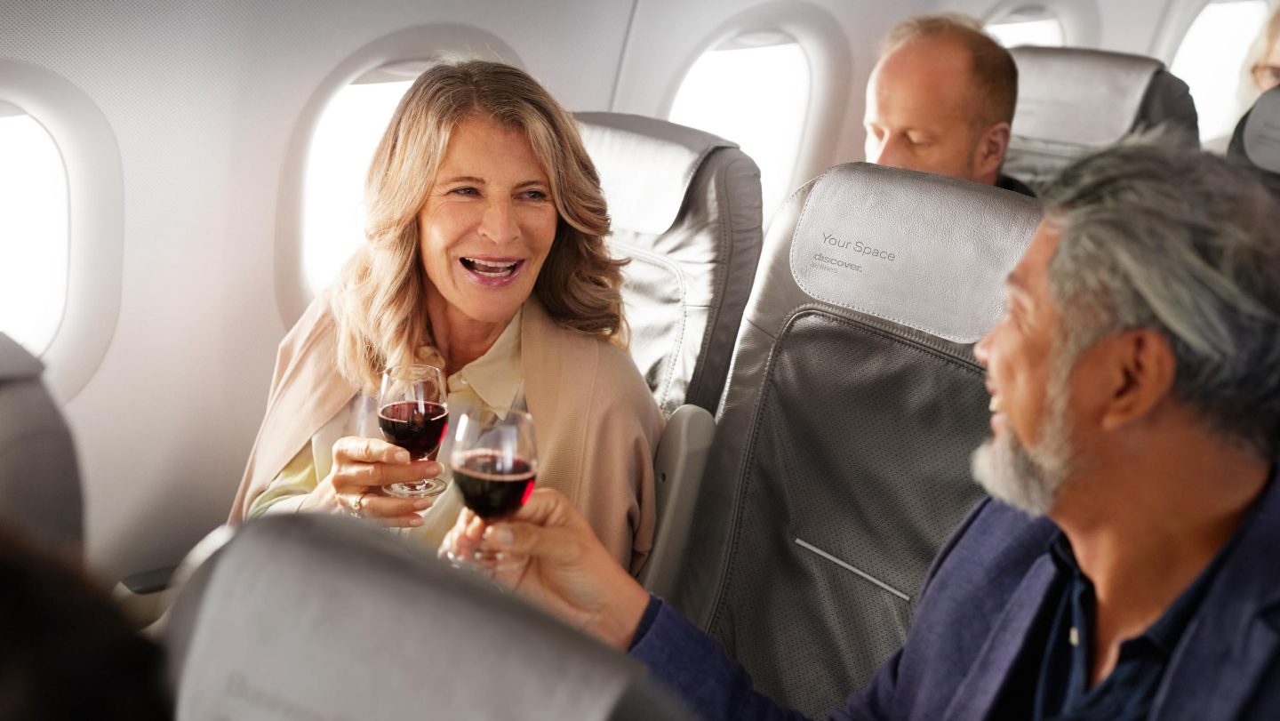 Un couple trinque avec du vin rouge en Business Class