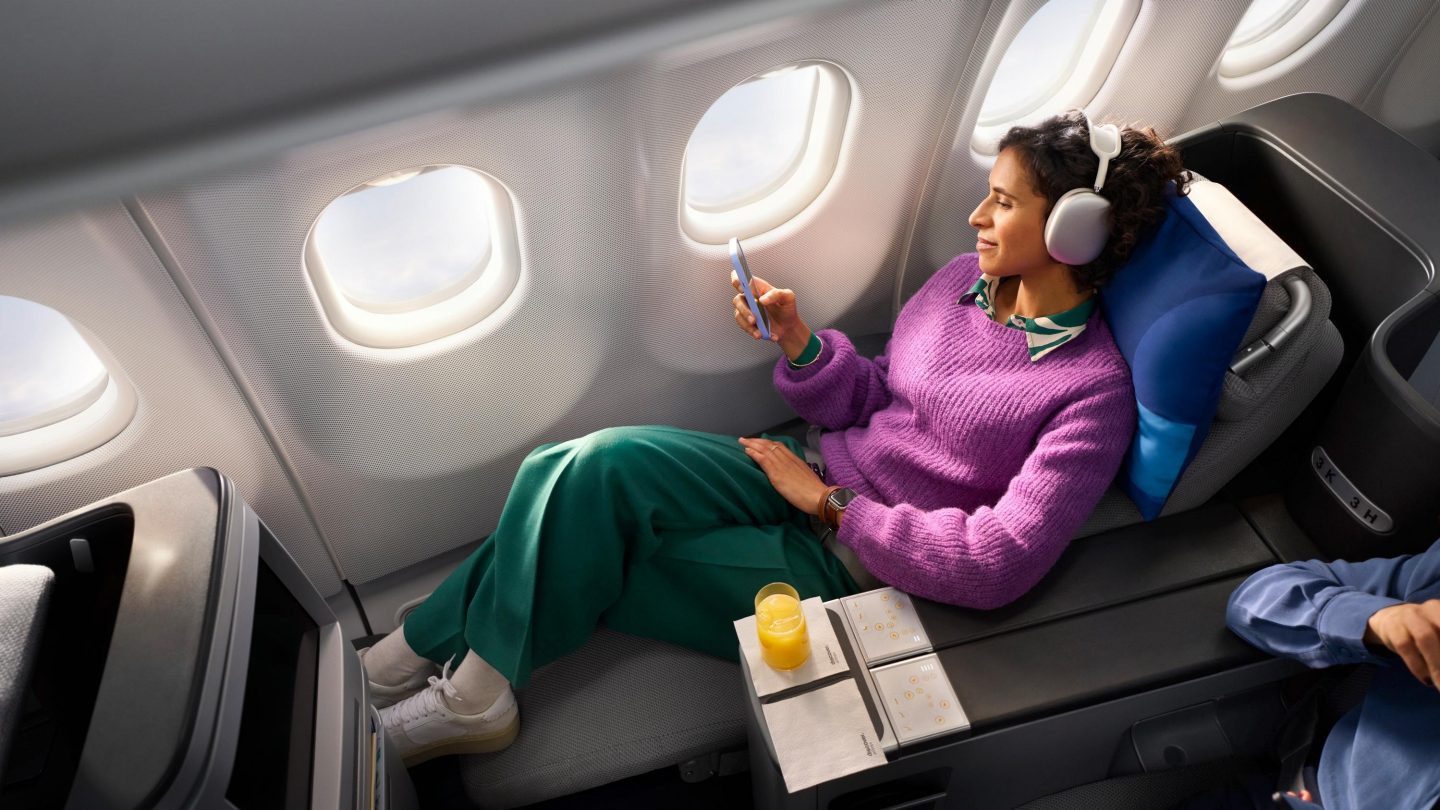 Eine Frau macht es sich auf einem Business Class Sitz bequem