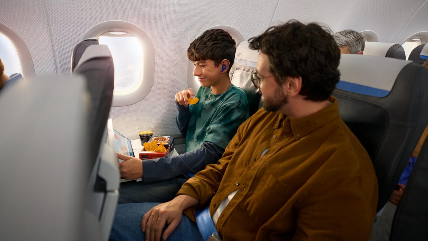 A father and his son watching the Onboard Cloud entertainment on a tablet