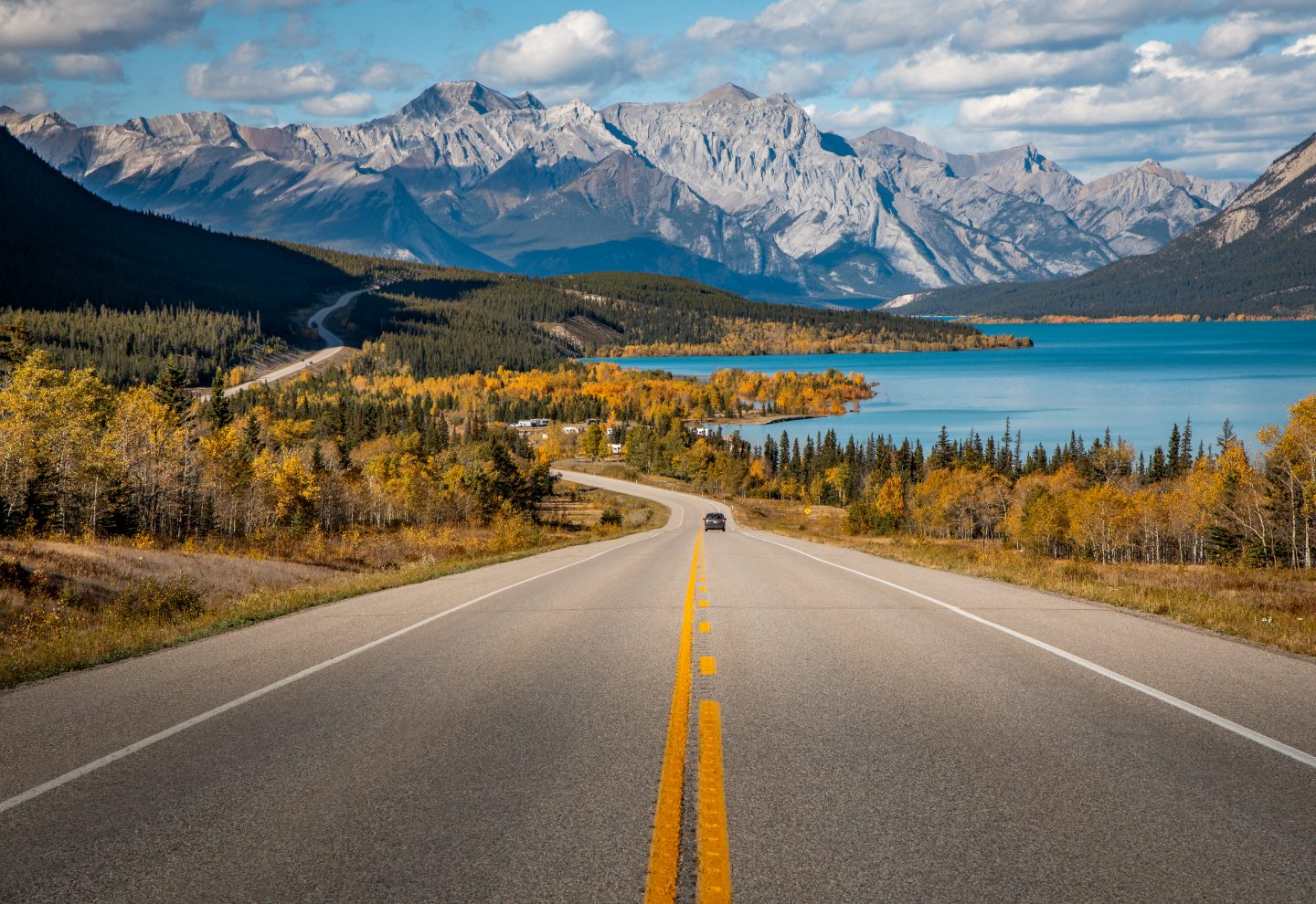 Road with blue lake and Alps in the background in Banff National Park