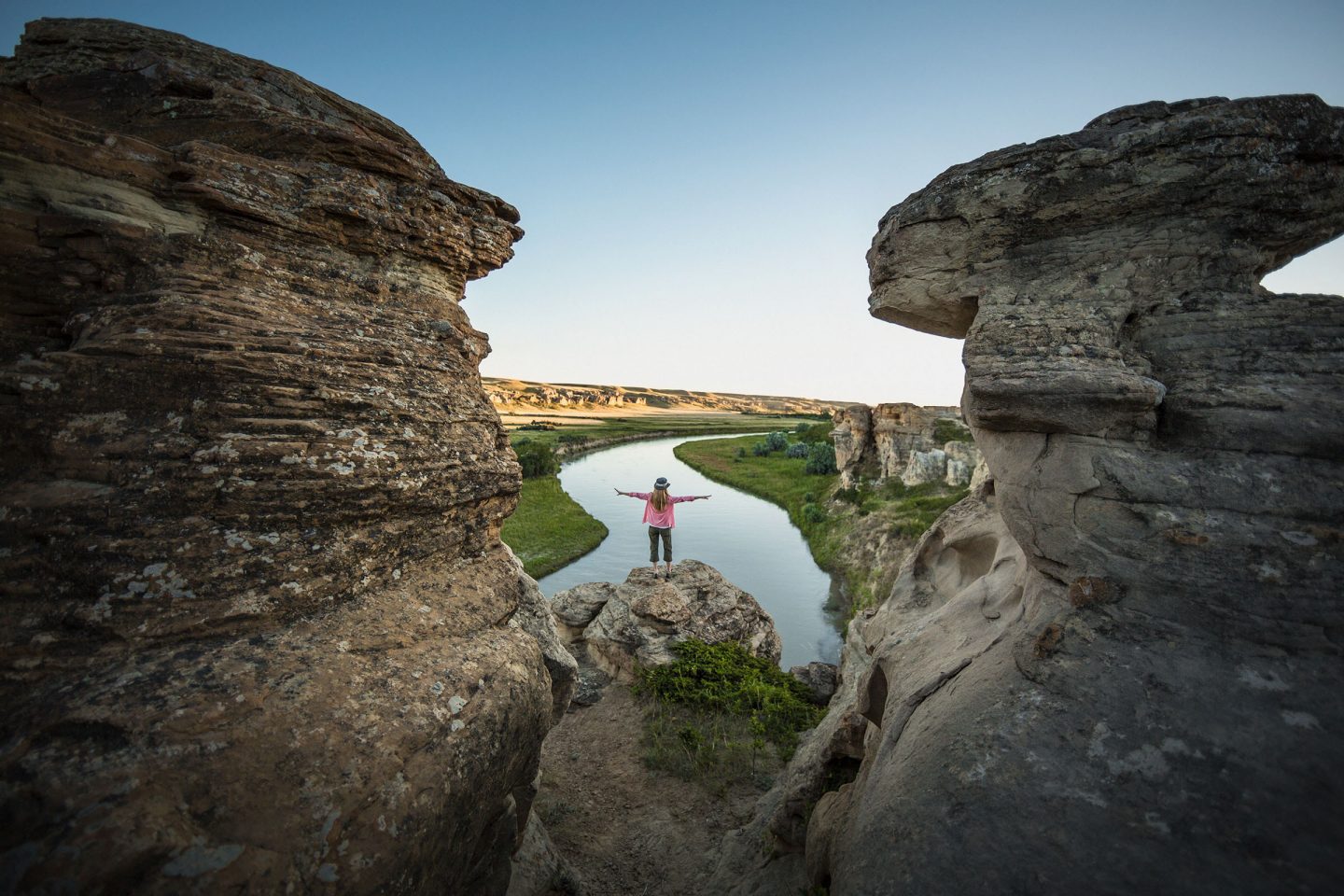 Calgary-Urlaub: Eine Frau steht zwischen zwei Felsen und schaut auf die Landschaft