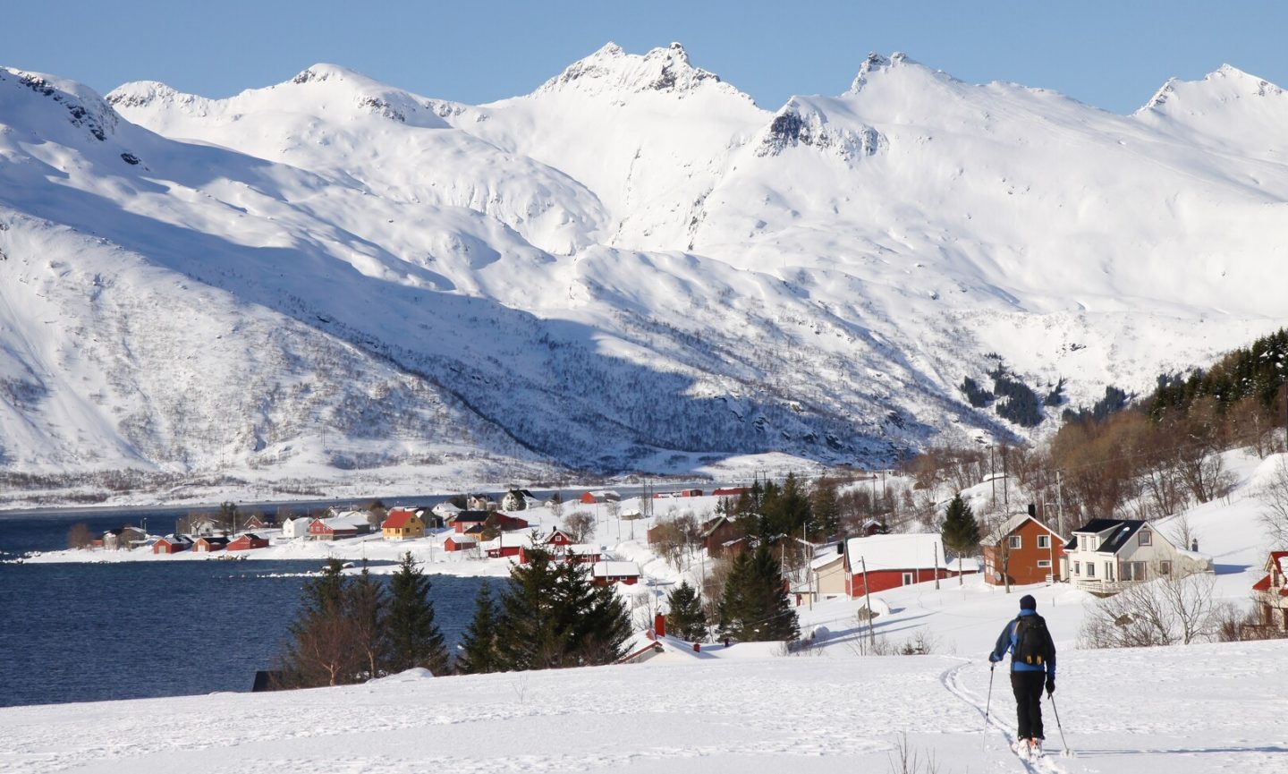 A person on skis with snow-capped mountains in the background