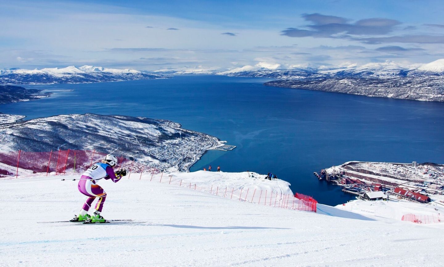 A person skiing with a view of fjords and mountains