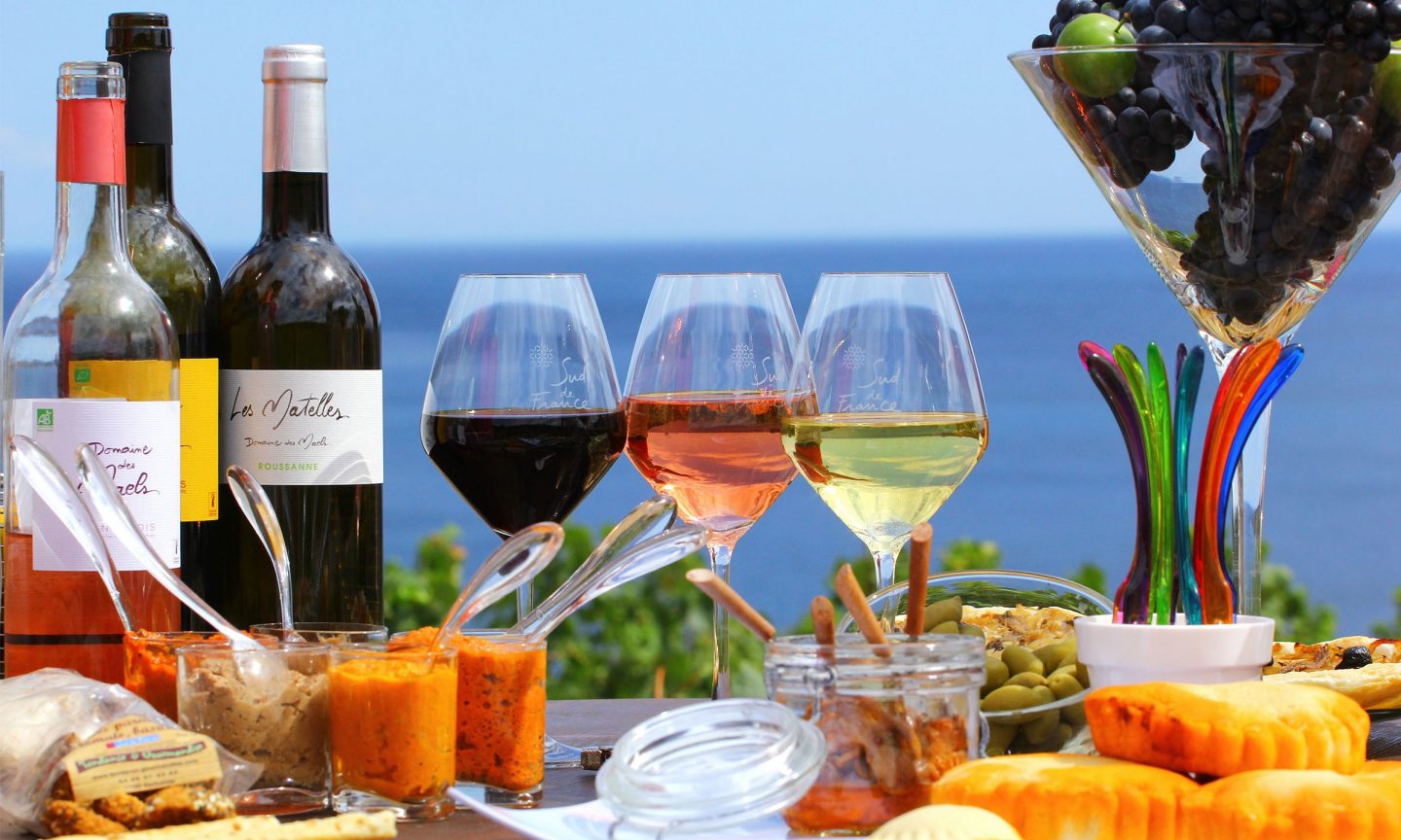 Tisch gedeckt mit Wein, Käse, Oliven und Dips