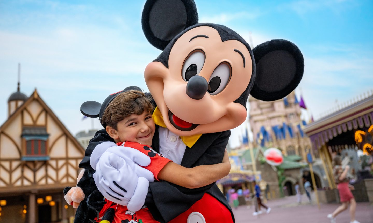 Mickey Mouse holding a child in its arms at Disney World Orlando