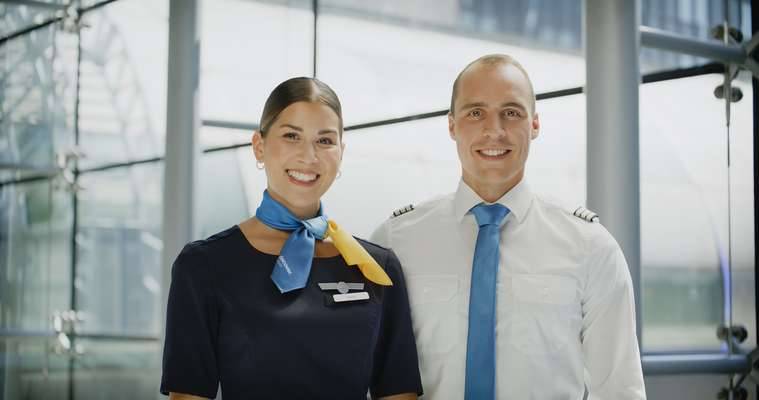 Discover Airlines Cabin Managerin und Pilot in Uniform stehen nebeneinander