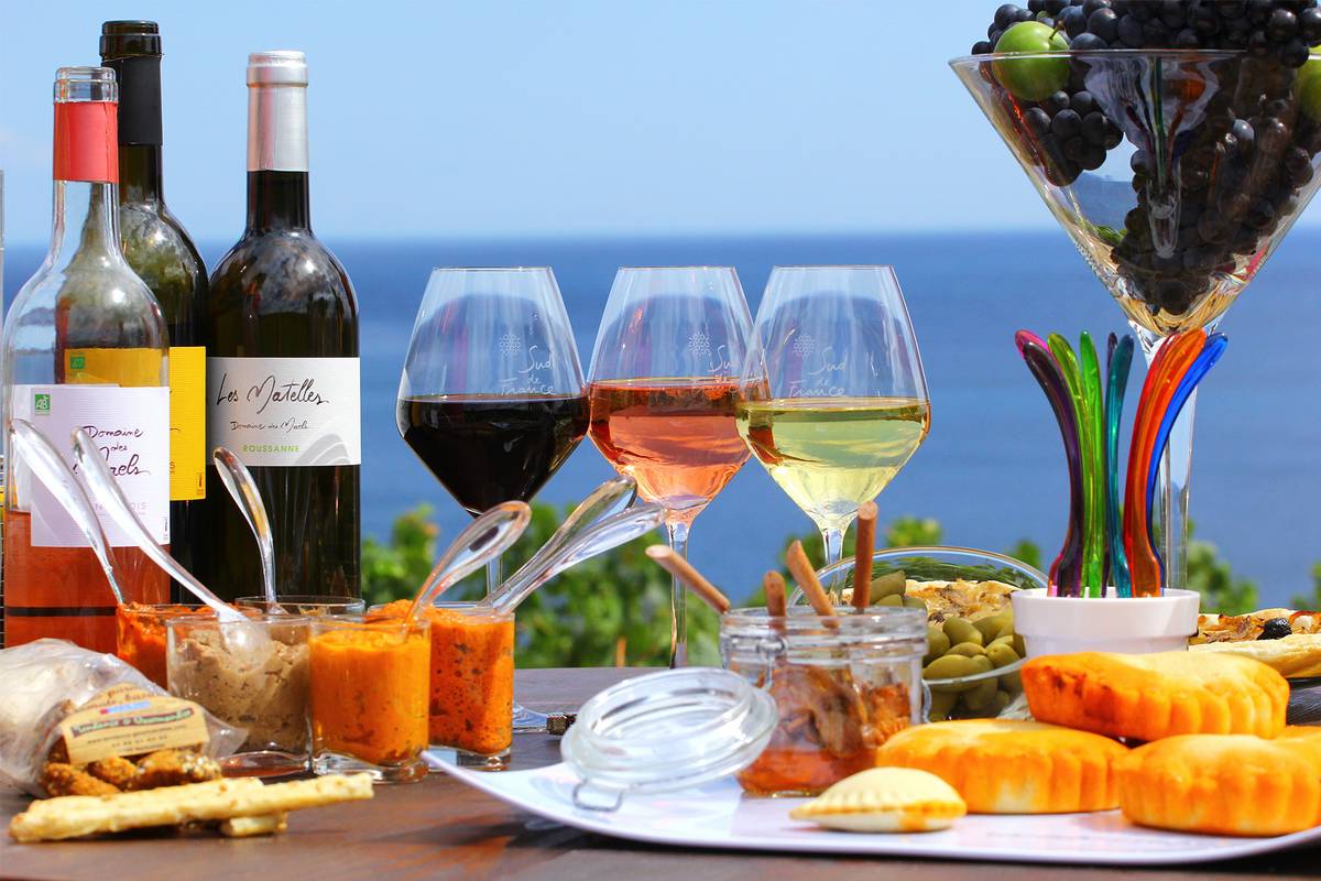 Tisch gedeckt mit Wein, Käse, Oliven und Dips