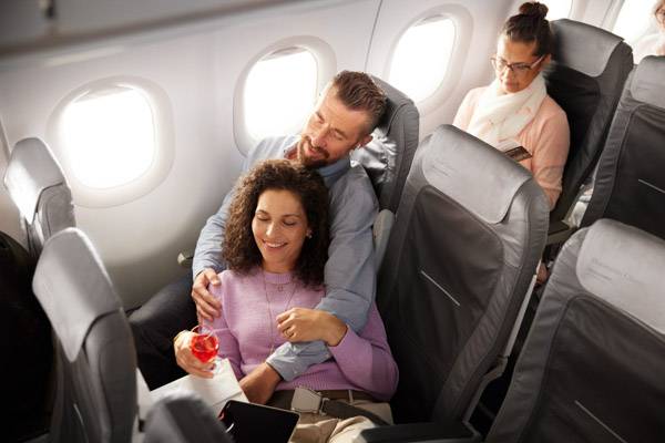 A couple in love sitting in Business Class of an A320