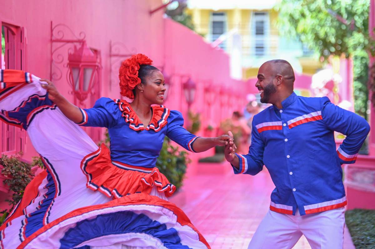 A woman and a man dance merengue