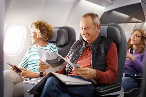 A couple sitting in Premium Economy Class and reading