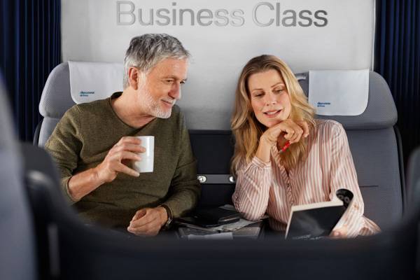 Mann und Frau sitzen in der Business Class und lesen