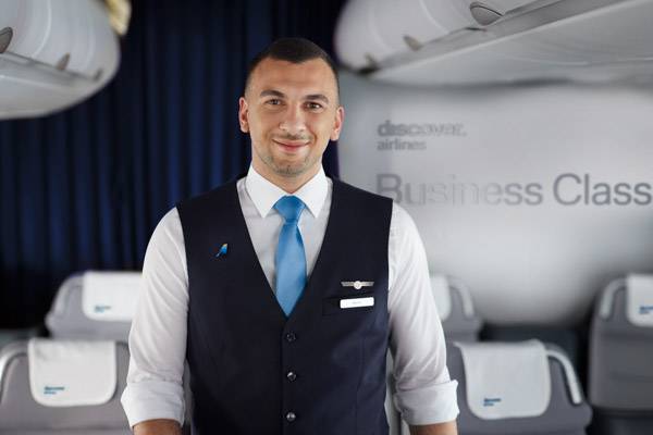 Discover Airlines Flugbegleiter steht in der Business Class
