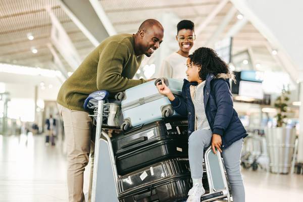 Familie steht mit Koffern am Flughafen