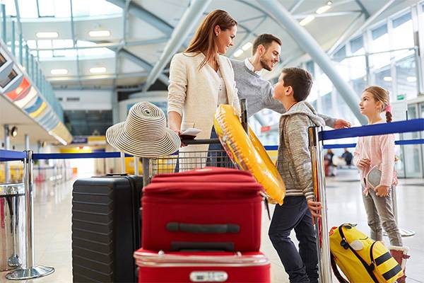 A family is standing at the check-in counter with a lot of baggage