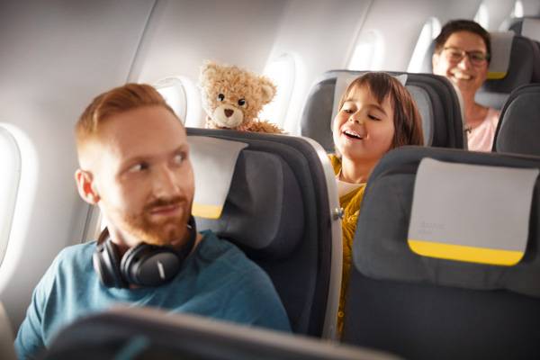 Child is sitting in Economy Class with his teddy bear