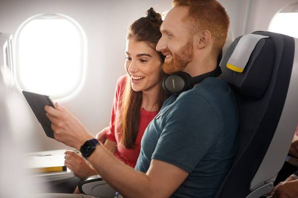 Couple looking at a tablet in Economy Class Longhaul