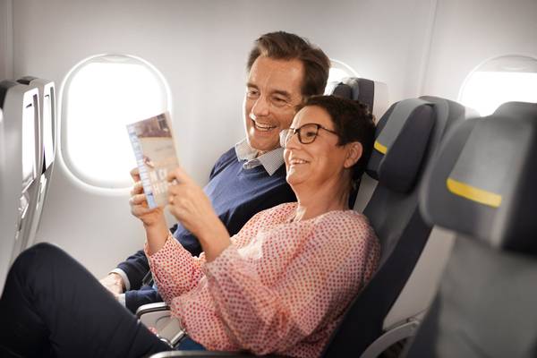 A couple sits in Economy Class and reads a book