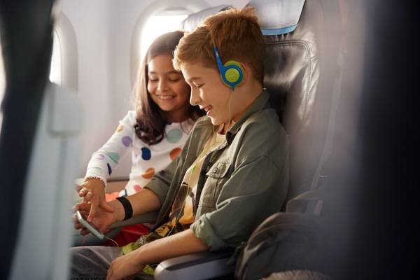 Children sitting in Economy Class and using the entertainment program 